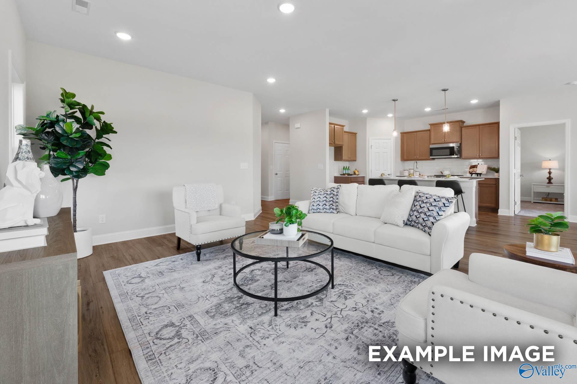 Open-concept living room and kitchen in The Franklin C floor plan by Davidson Homes in Heritage Lakes, New Market, Alabama.