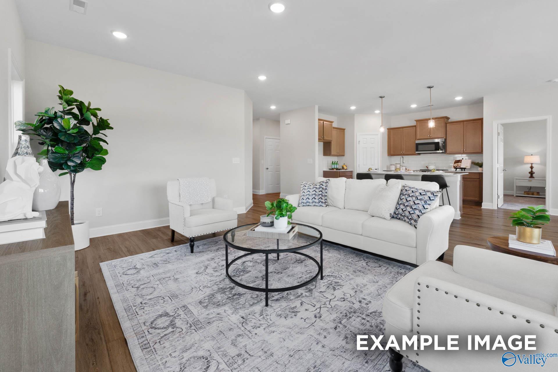 Open-concept living room and kitchen in The Franklin C floor plan by Davidson Homes in Heritage Lakes, New Market, Alabama.