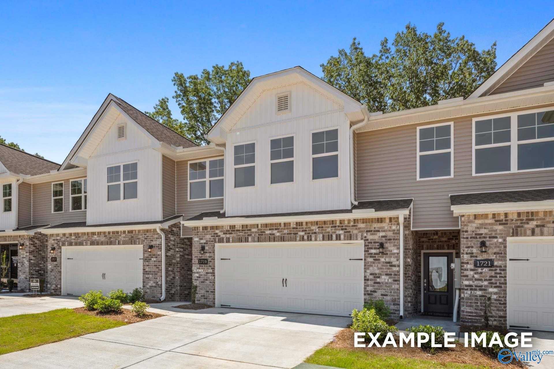Modern two-story townhomes with beige siding, brick accents, two-car garages in Pavilion, Huntsville, Alabama by Davidson Homes The Camden C