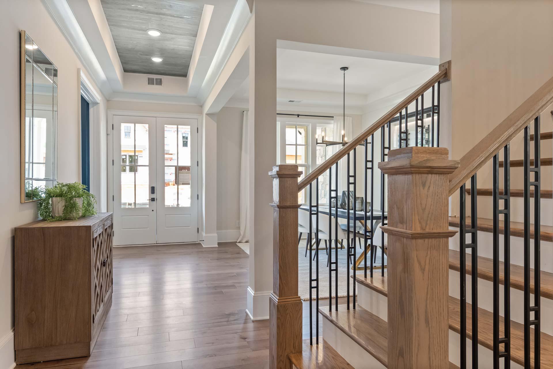 Elegant foyer in Tanglewood East Cobb Georgia home by Davidson Homes featuring oak staircase black metal railing and hardwood floors