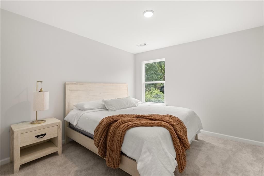 Bright, neutral secondary bedroom with cozy decor in The Sinclair B floor plan at Cedar Farms, Winder, Georgia.