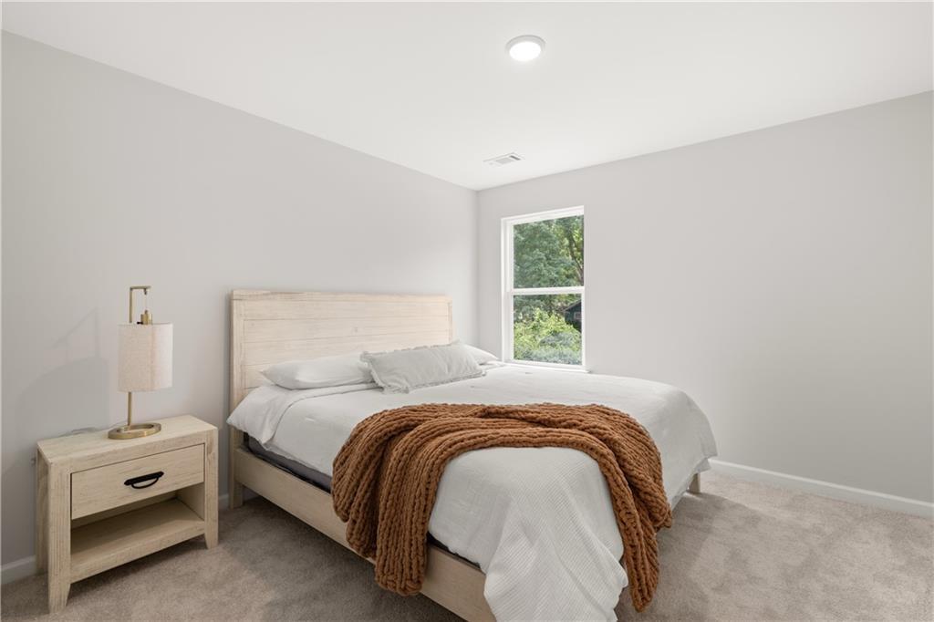 Bright, neutral secondary bedroom with cozy decor in The Sinclair B floor plan at Cedar Farms, Winder, Georgia.