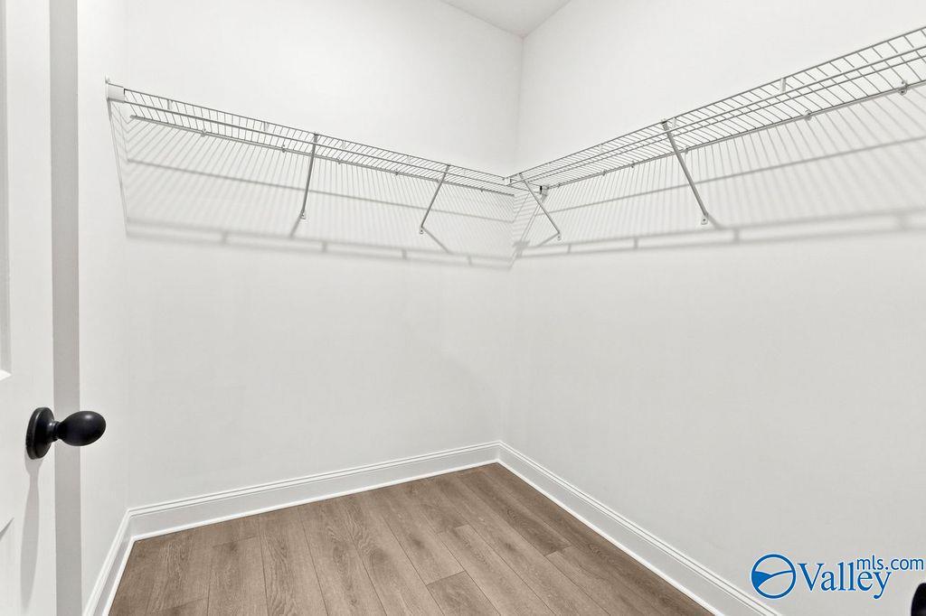 Walk-in closet with wire shelving and wood-look flooring in The Camilla B floor plan at The Retreat at Cain Park, Hartselle.