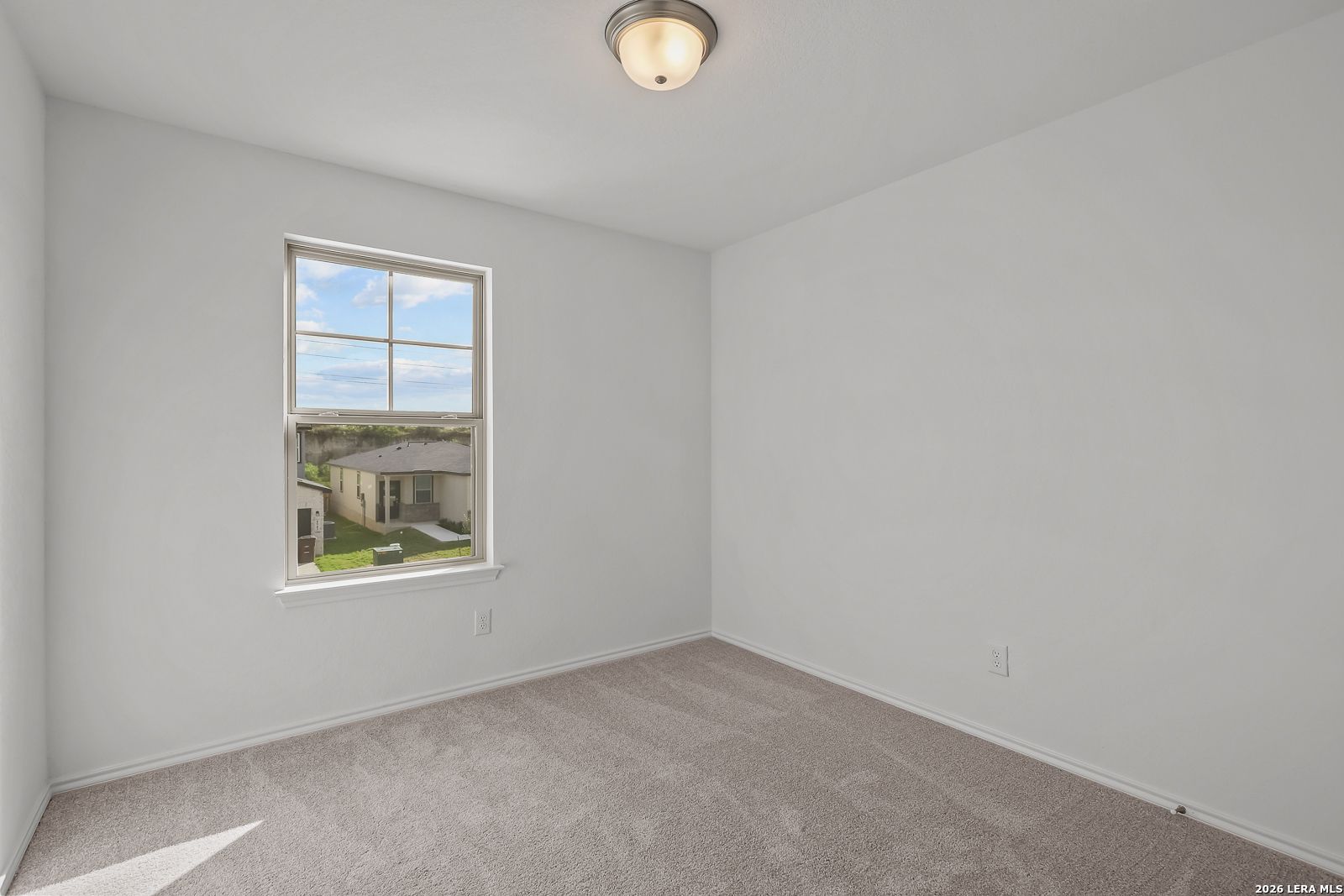 Bright, carpeted bedroom with neutral walls in The Brazos B floor plan by Davidson Homes in Agave, San Antonio, Texas.