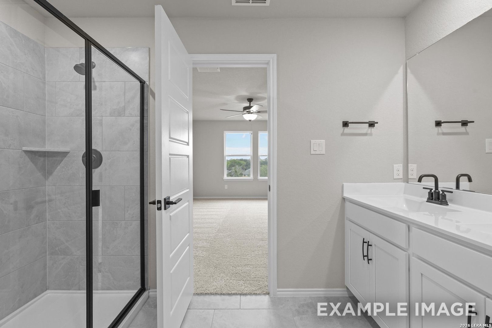 Modern bathroom with glass walk-in shower, dual vanity, and matte black fixtures in Davidson Homes The Murray H, Converse, Texas