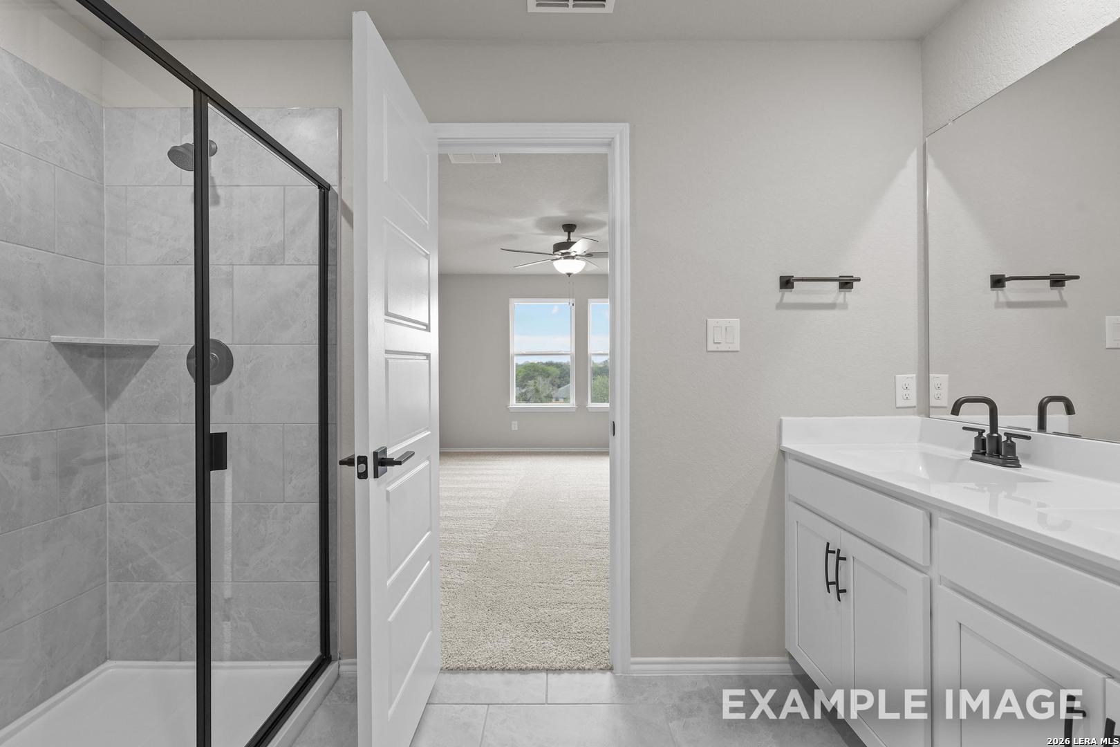 Modern bathroom with glass walk-in shower, dual vanity, and matte black fixtures in Davidson Homes The Murray H, Converse, Texas