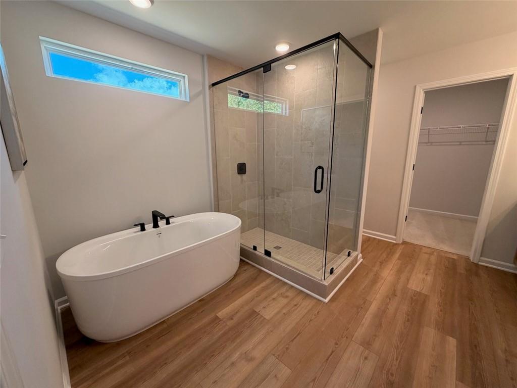 Freestanding soaking tub and glass walk-in shower in master bath of Davidson Homes Pinecrest J in Greene Farm, Cartersville, Georgia