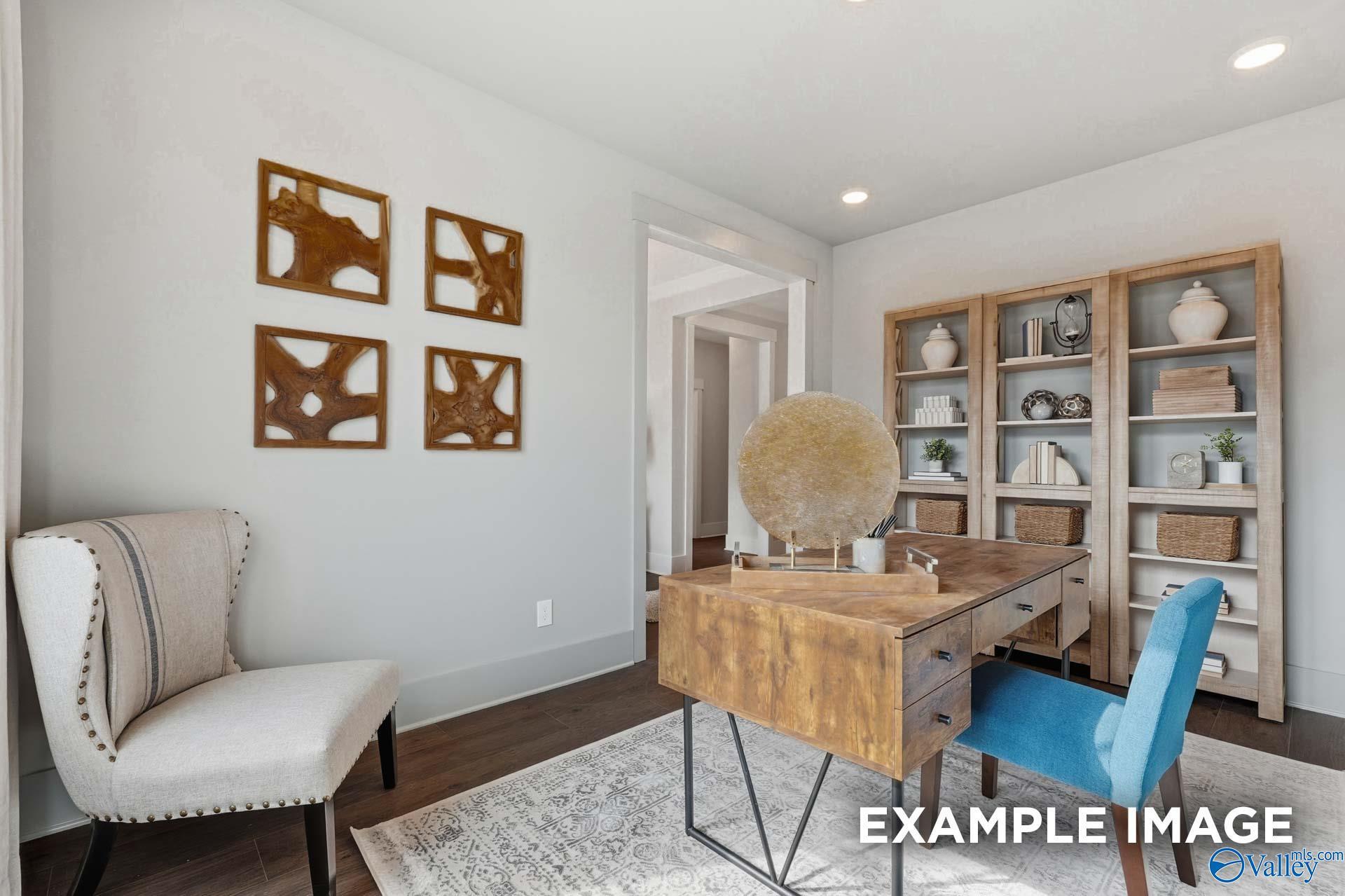 Stylish home office with rustic wood desk, built-in bookshelves, and accent chairs in Davidson Homes The Hibiscus F, Arab, Alabama