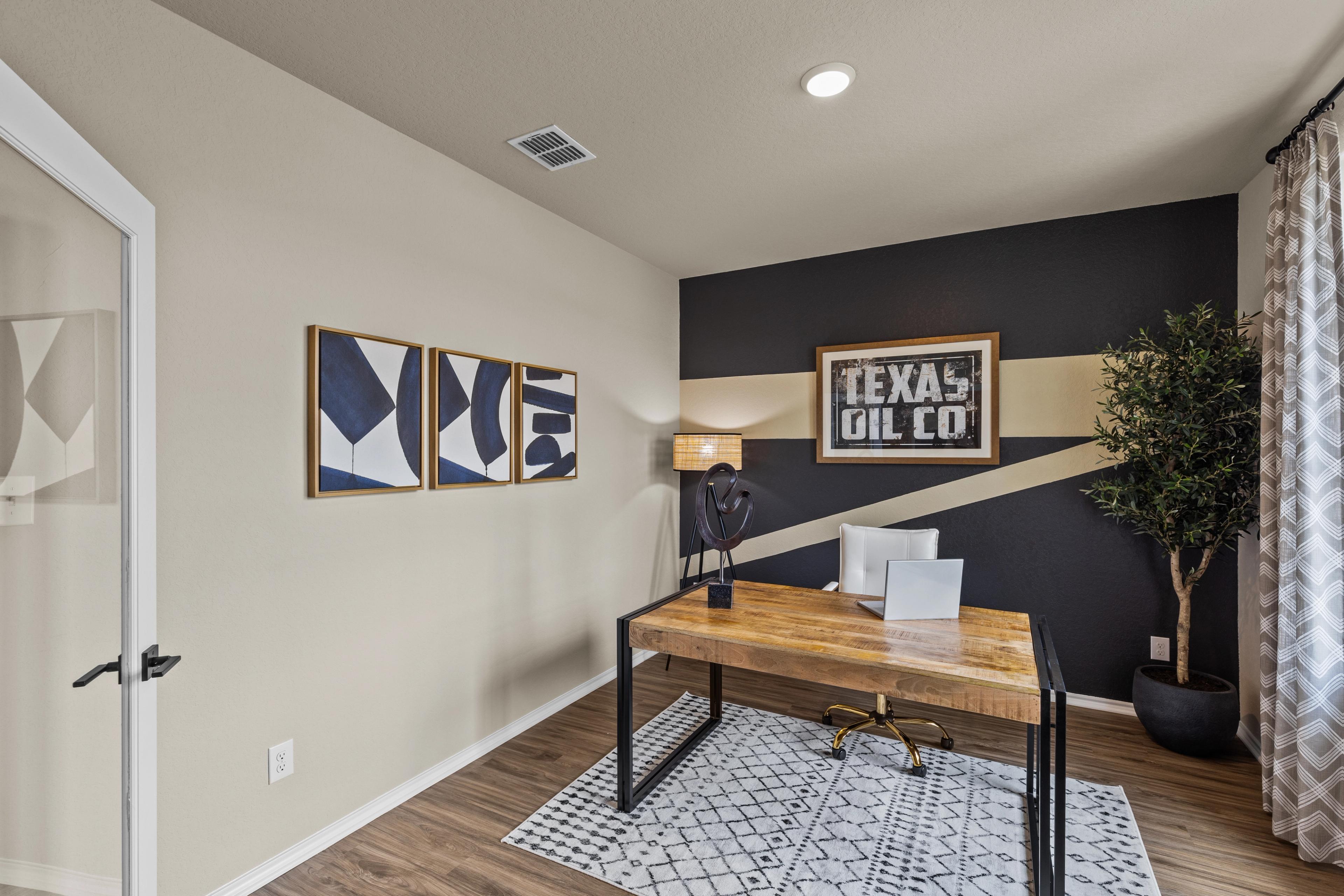Contemporary home office in Bricewood San Antonio TX featuring wooden desk, Texas Oil Co wall sign, abstract art, and potted plant
