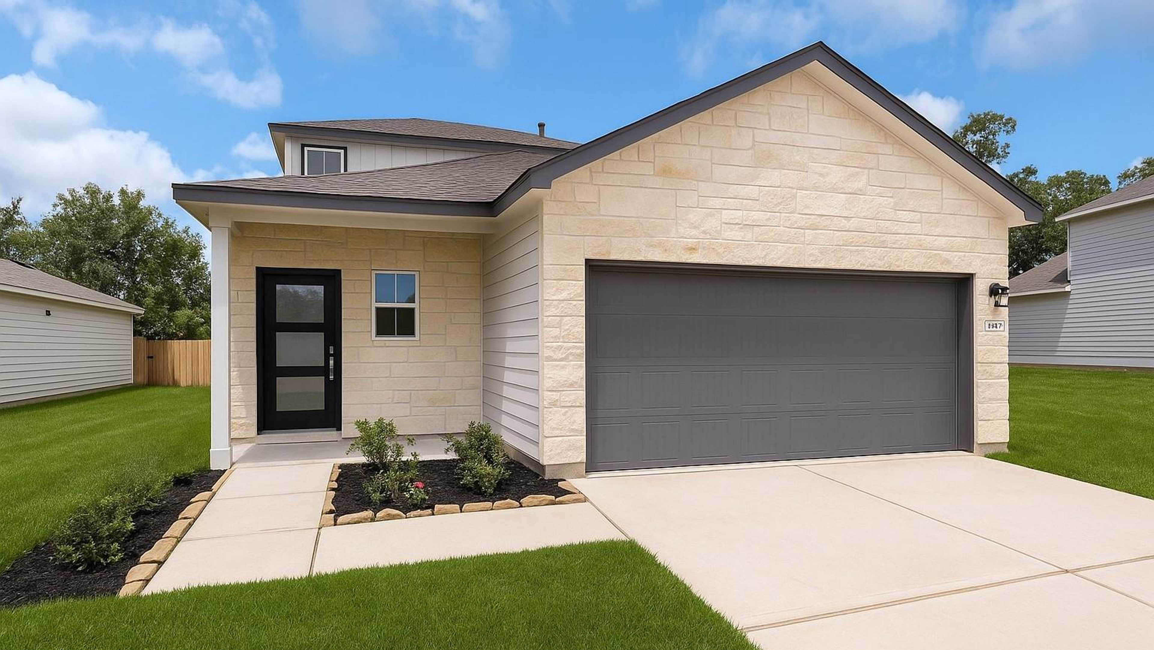 Modern beige stone two-story home with garage, landscaped yard, and walkway at Davidson Homes open house on Caney Creek Court
