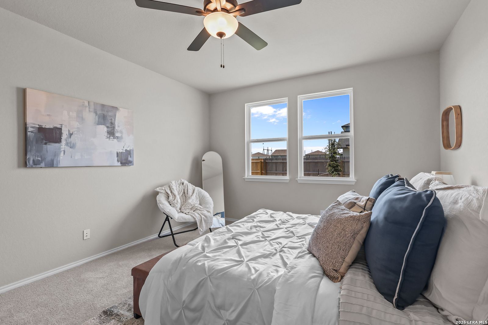 Bright bedroom with ceiling fan and plush bedding in The Daphne H floor plan at Hannah Heights in Seguin, Texas.