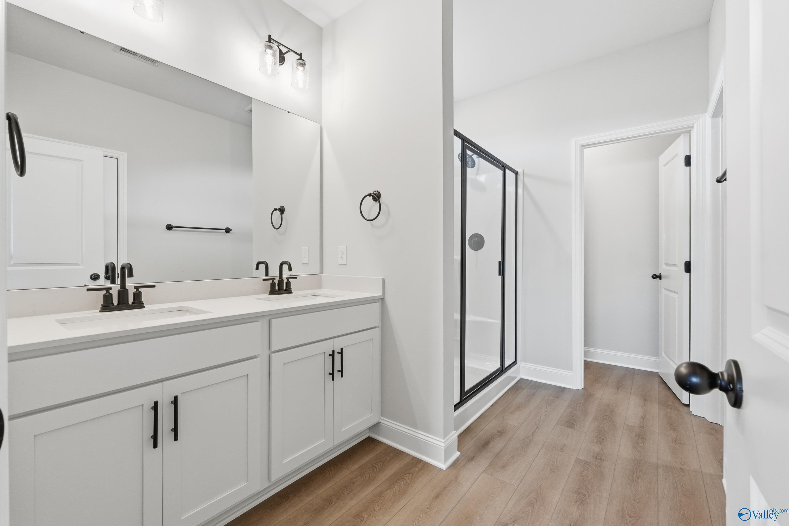 Modern master bath with double vanity, frameless glass shower, white shaker cabinets in Davidson Homes The Daphne D, Arab, AL