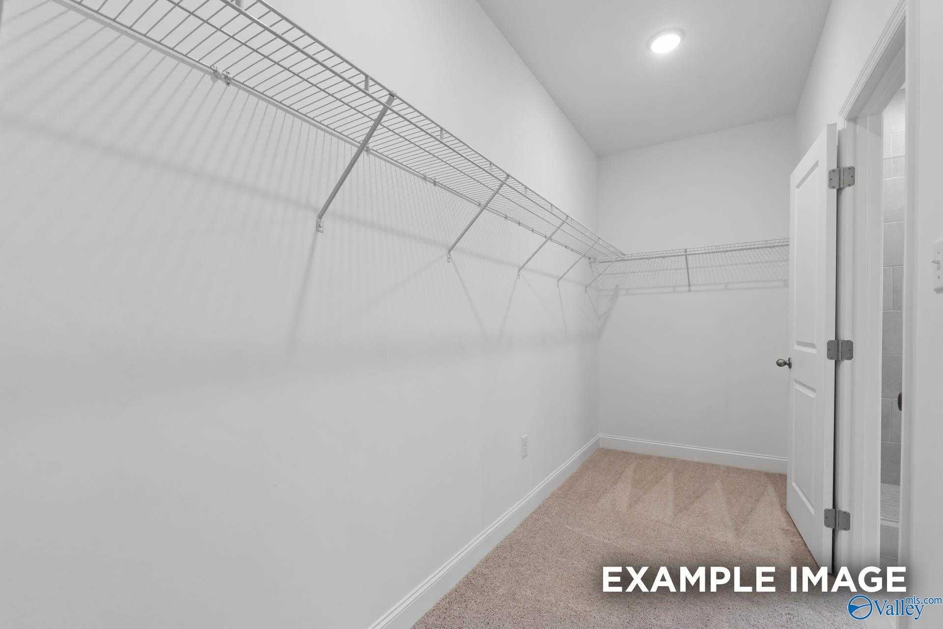 Spacious walk-in closet with wire shelving and white walls in The Montgomery 3-bedroom home by Davidson Homes, Meridianville, Alabama