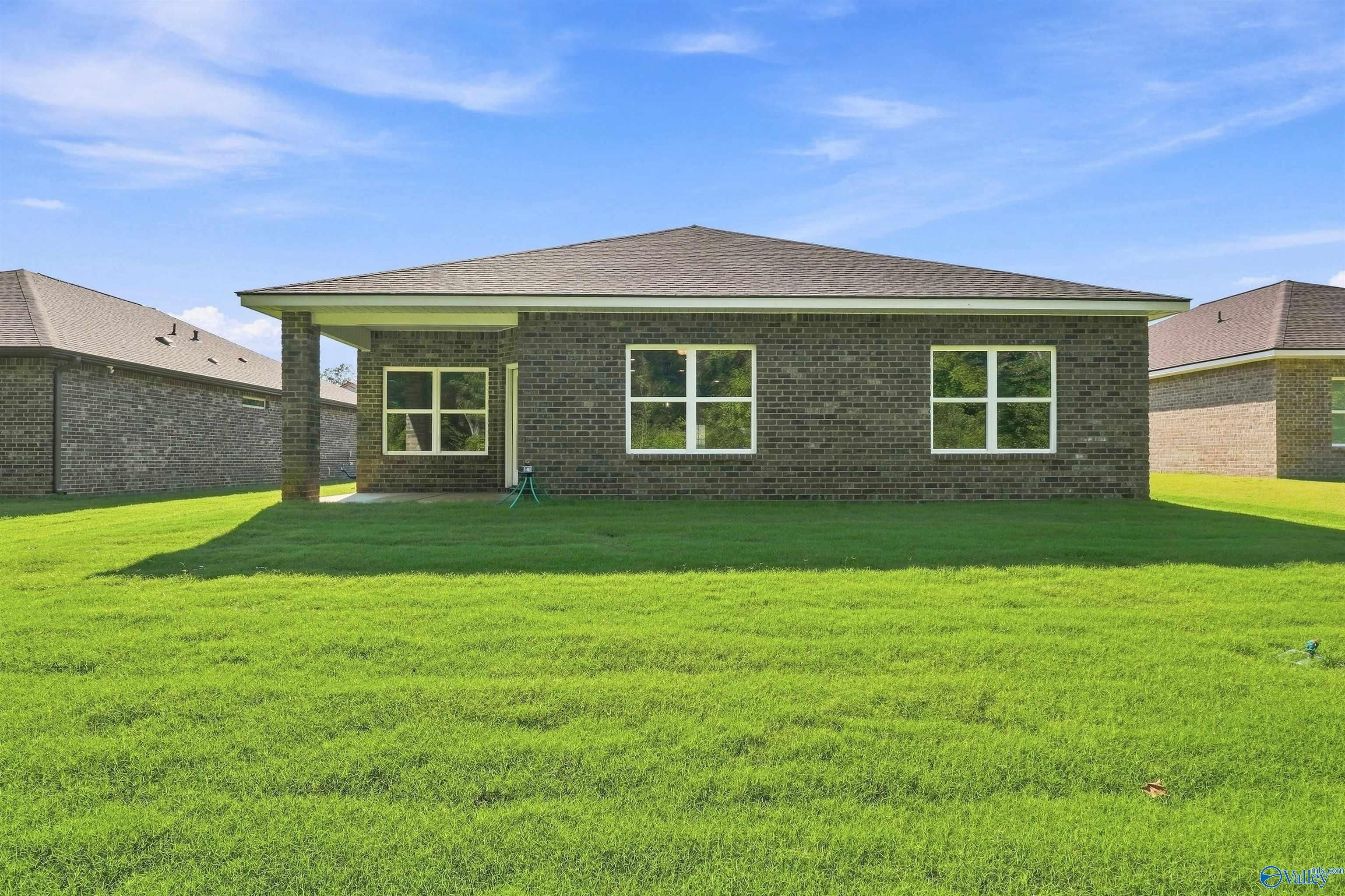 Back exterior view of The Daphne floor plan by Davidson Homes featuring a spacious backyard in Spragins Cove, Huntsville.