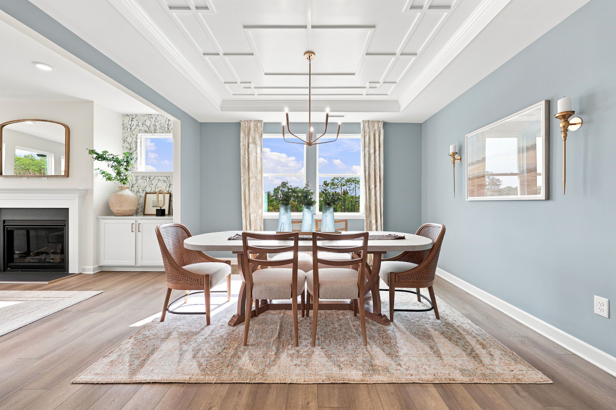 Elegant dining room at Montrose in Aberdeen, NC by Davidson Homes featuring a coffered ceiling and modern chandelier.