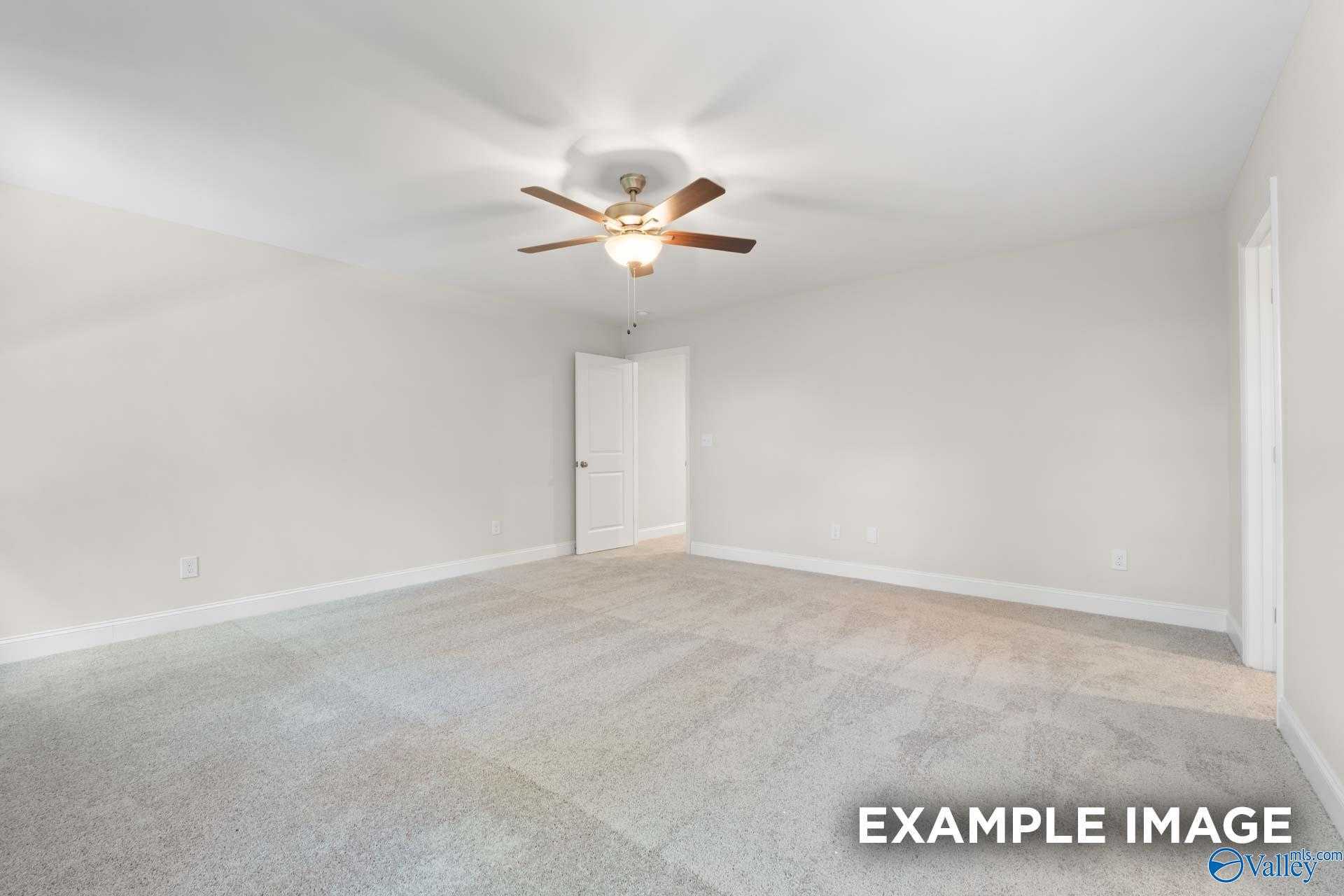 Empty bedroom with white walls, ceiling fan, and beige carpet in The Camden C floor plan by Davidson Homes, Huntsville, Alabama