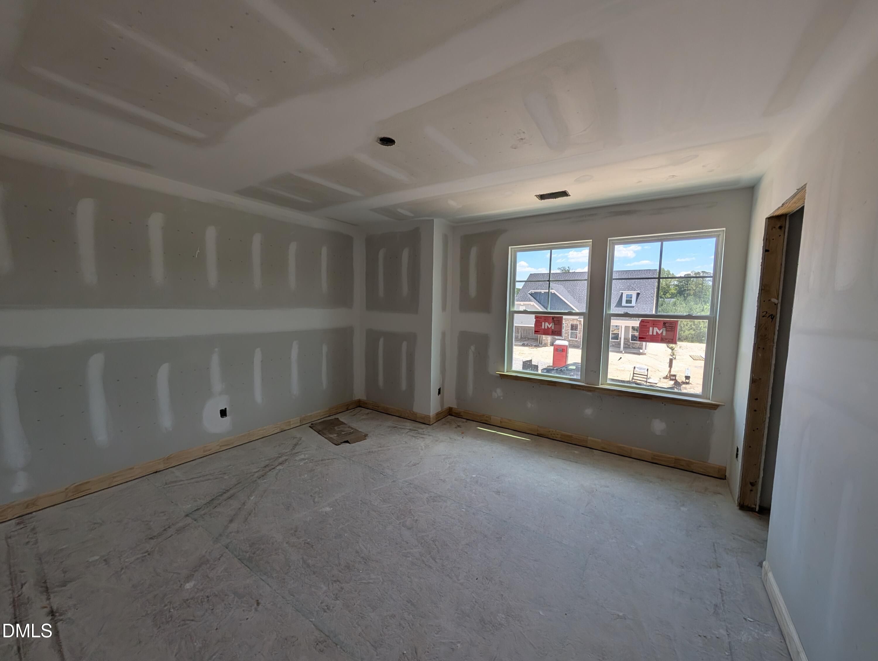 Unfinished bedroom with drywall and tray ceiling in The Chestnut floor plan at Wendell Ridge, Wendell, North Carolina.