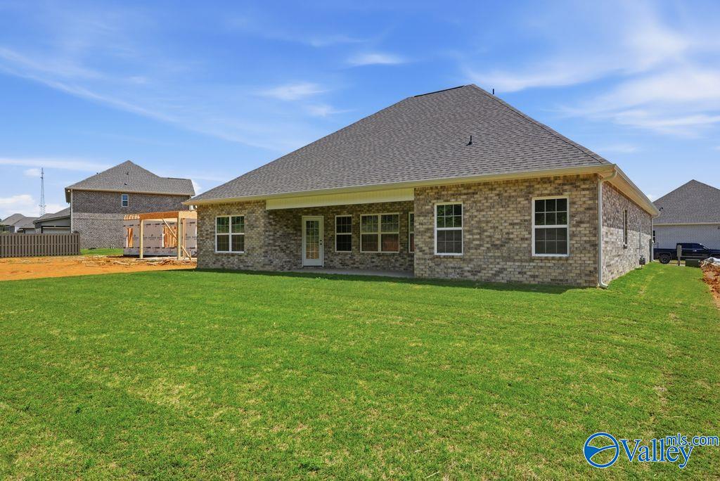 Back exterior view of The Rockford with Bonus home featuring a spacious grassy backyard in Cain Park, Hartselle, Alabama.