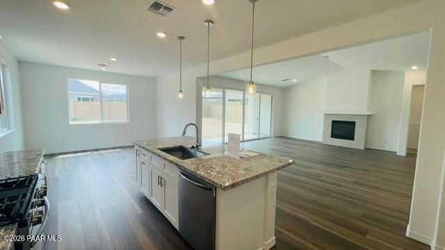 Open-concept kitchen with granite island and fireplace in The Summit A floor plan by Davidson Homes, Prescott, Arizona.