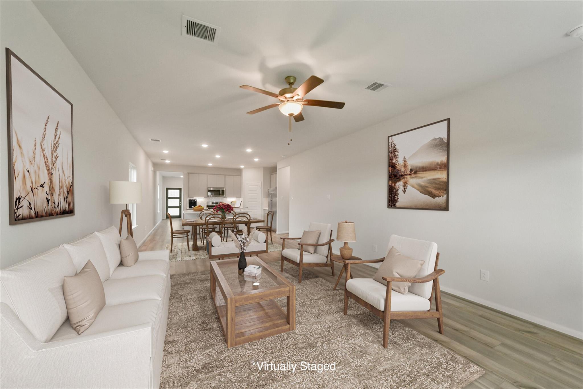 Bright open-concept living room with modern sofa, armchairs, dining table, and artwork in Davidson Homes San Marcos E, Beasley, Texas