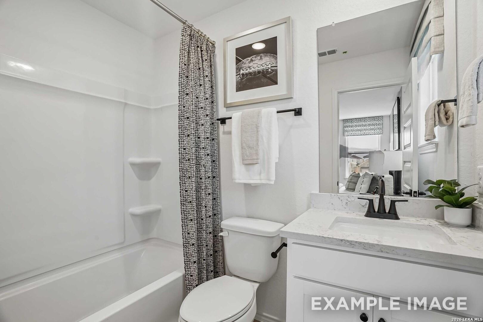 Bright white bathroom with marble vanity, black fixtures, tub shower, and toilet in Davidson Homes Pinecrest F plan, San Antonio