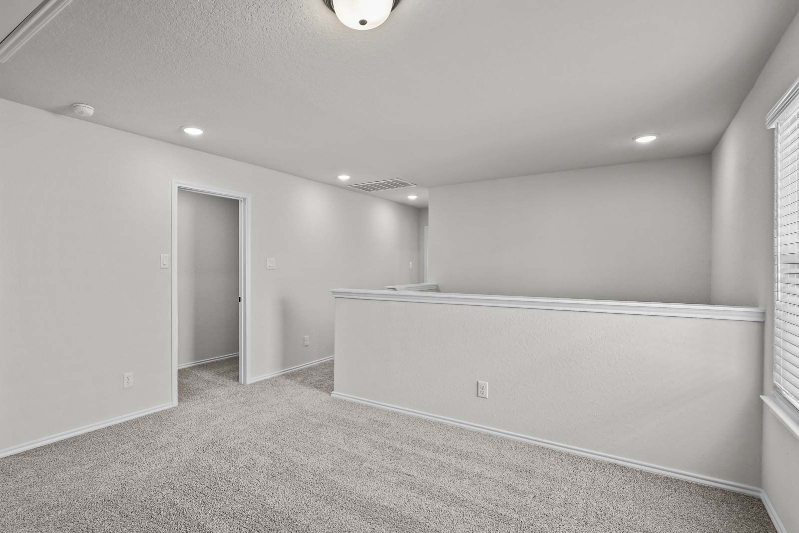 Spacious carpeted upper-level loft in The Florence B floor plan by Davidson Homes in San Antonio.