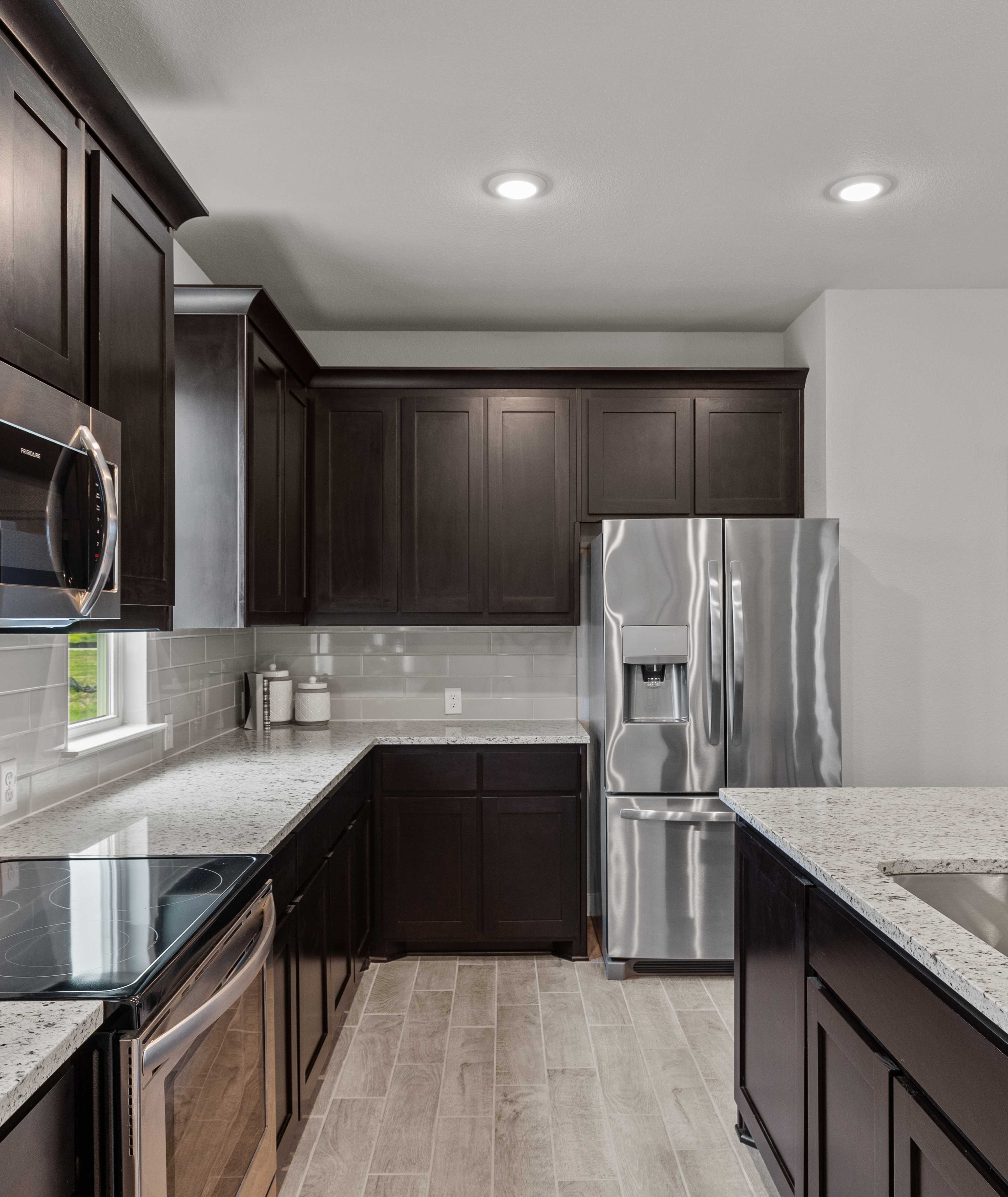 Modern kitchen with dark shaker cabinets, quartz counters, stainless appliances, and island at Agave in San Antonio TX