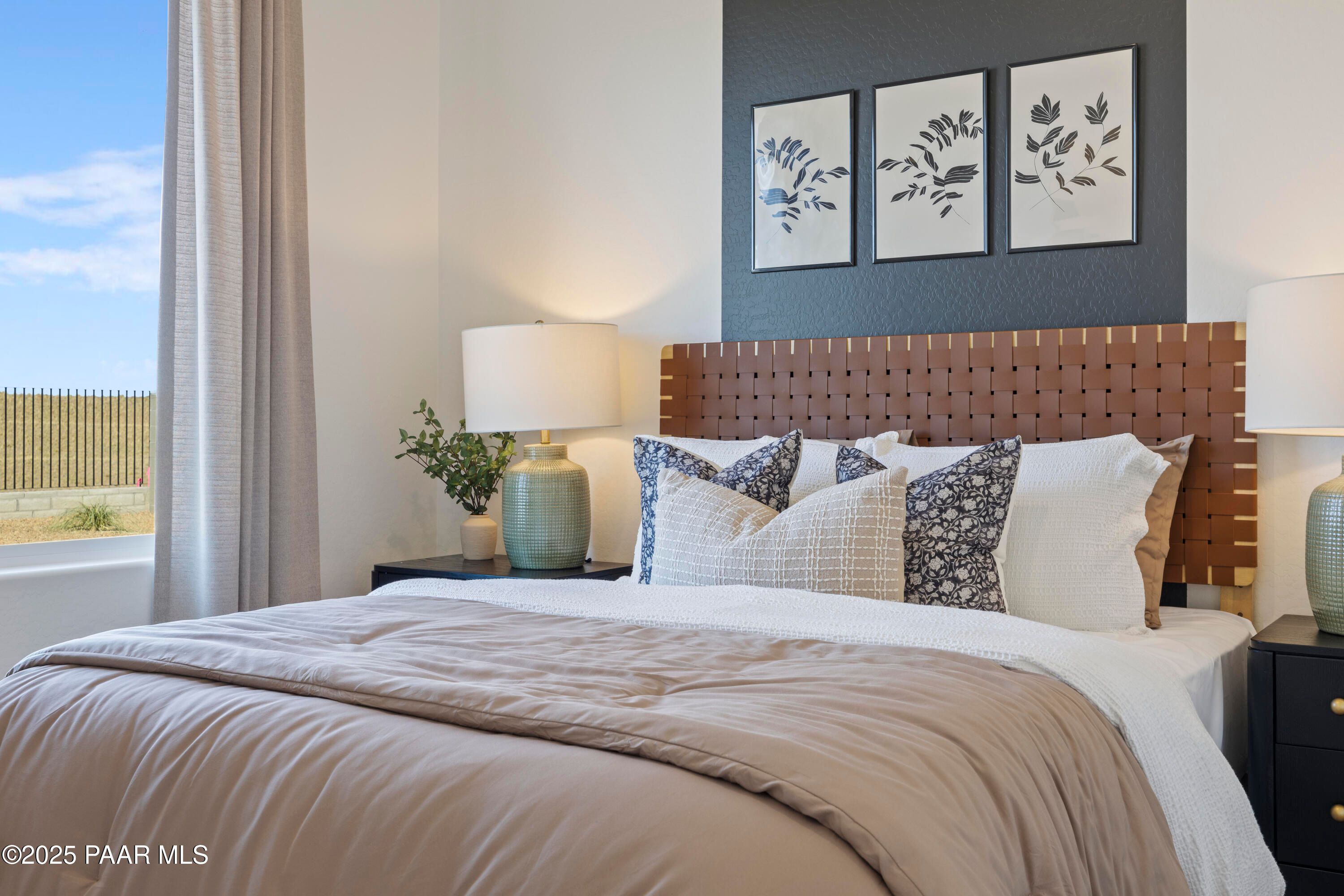 Serene master bedroom with woven wood headboard, botanical wall art, and desert view window in Davidson Homes The Blaze D, Prescott AZ