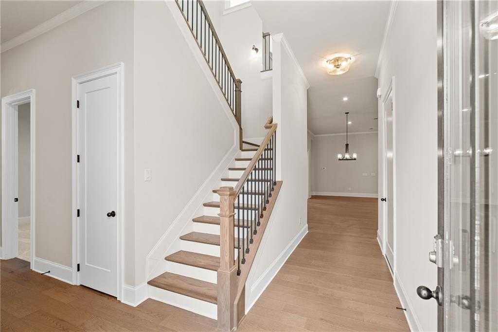 Elegant wooden staircase with black metal railings in foyer of 4-bedroom Davidson Homes The Seaside A, Woodstock, Georgia