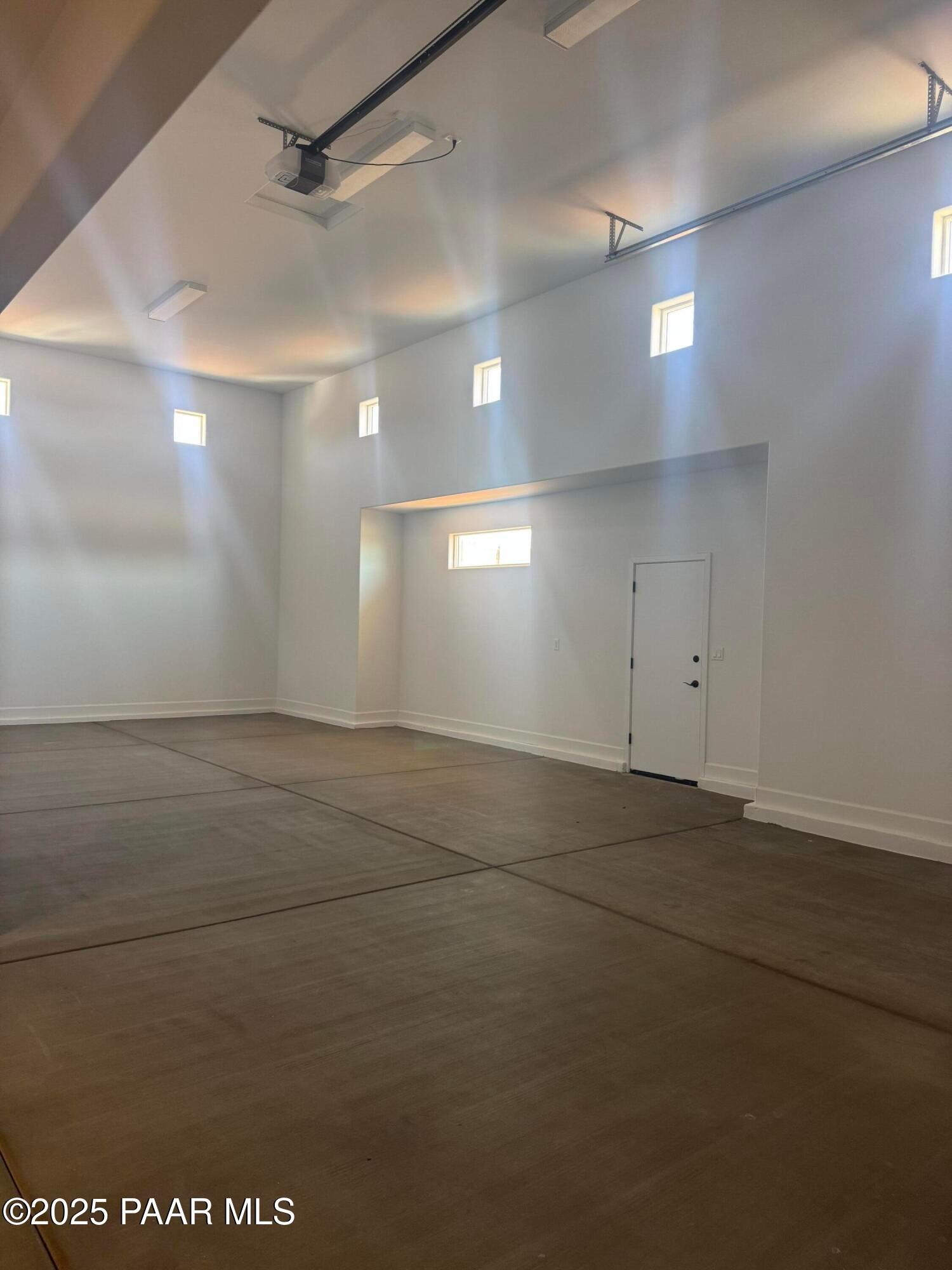 Spacious 2-car garage with polished concrete floor, clerestory windows, and overhead lighting in Evermore Homes The Summit B, Prescott Valley, Arizona