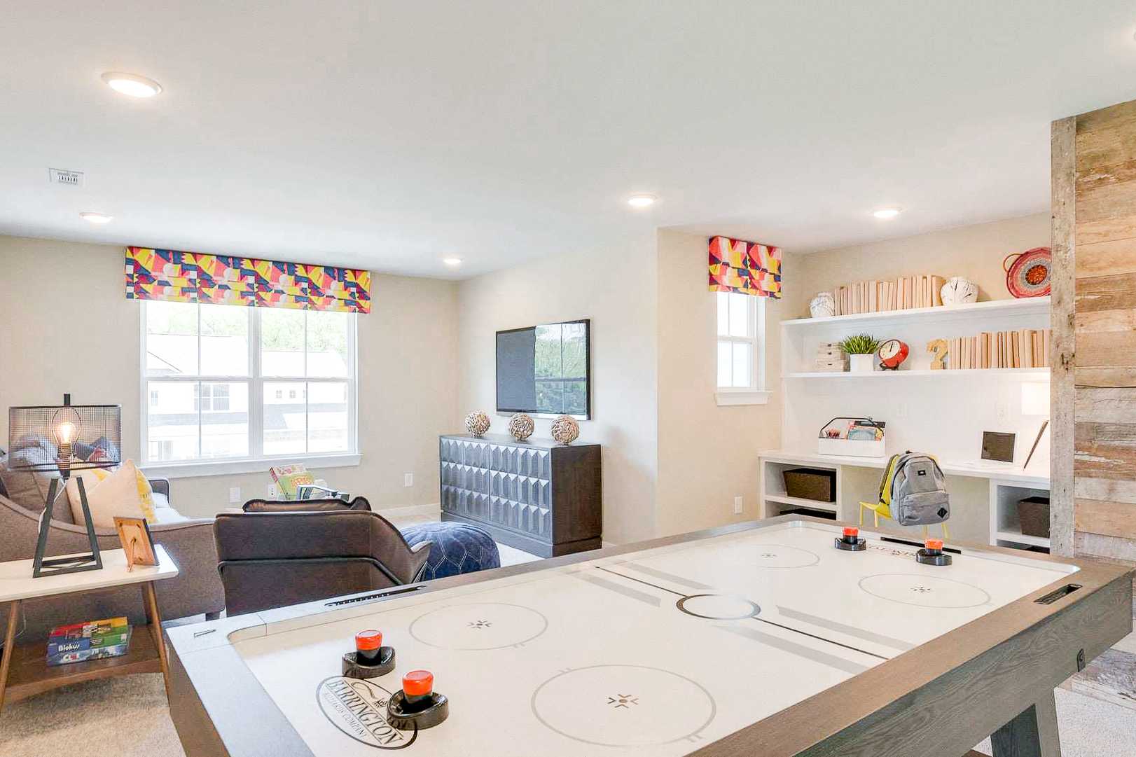 Spacious game room at The Meadows in Smyrna TN featuring foosball table, built-in bookshelves, and accent wall