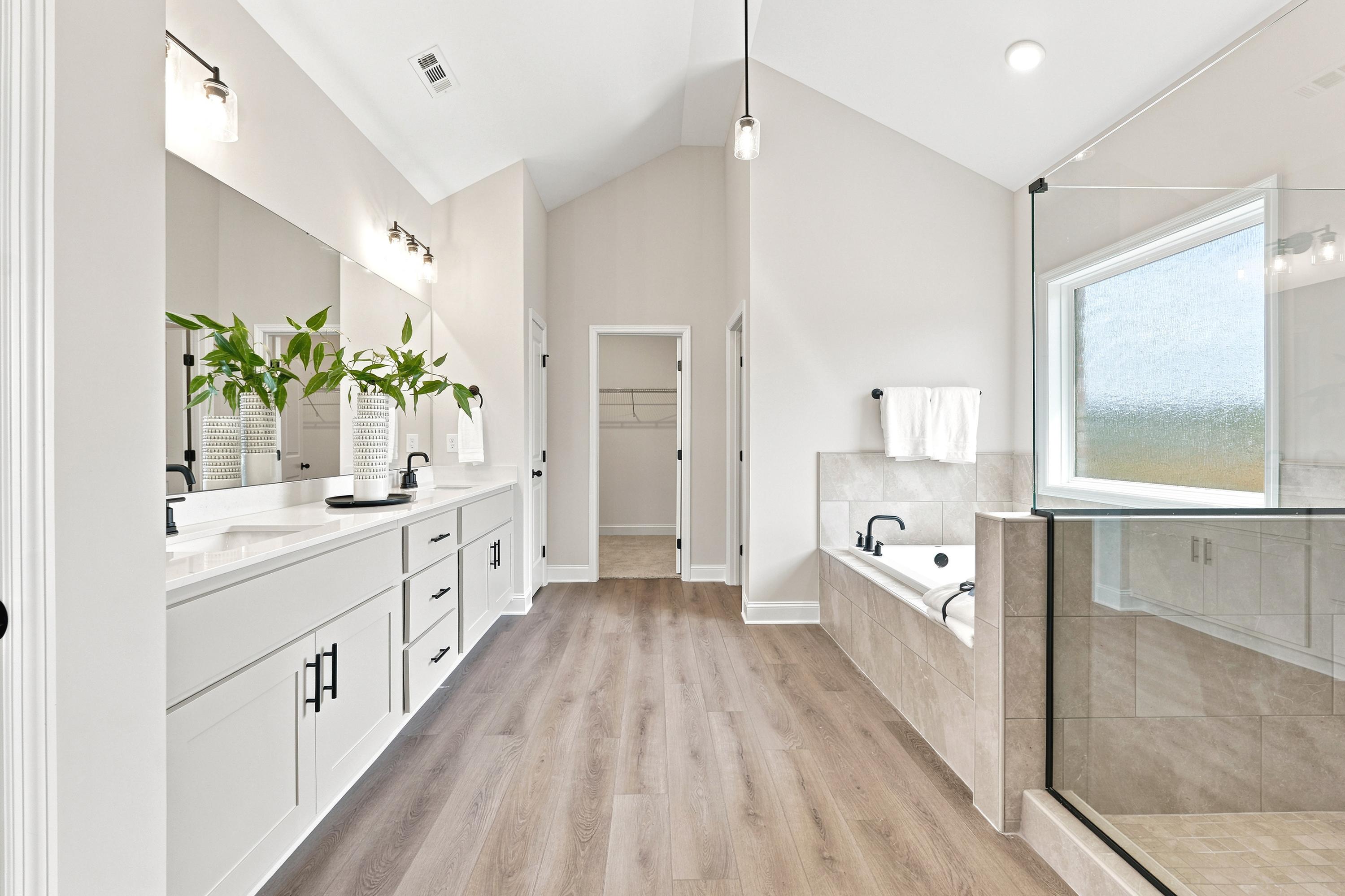 Primary bathroom at Riverton Preserve in Huntsville, AL featuring a dual vanity, soaking tub, and walk-in shower by Davidson Homes.