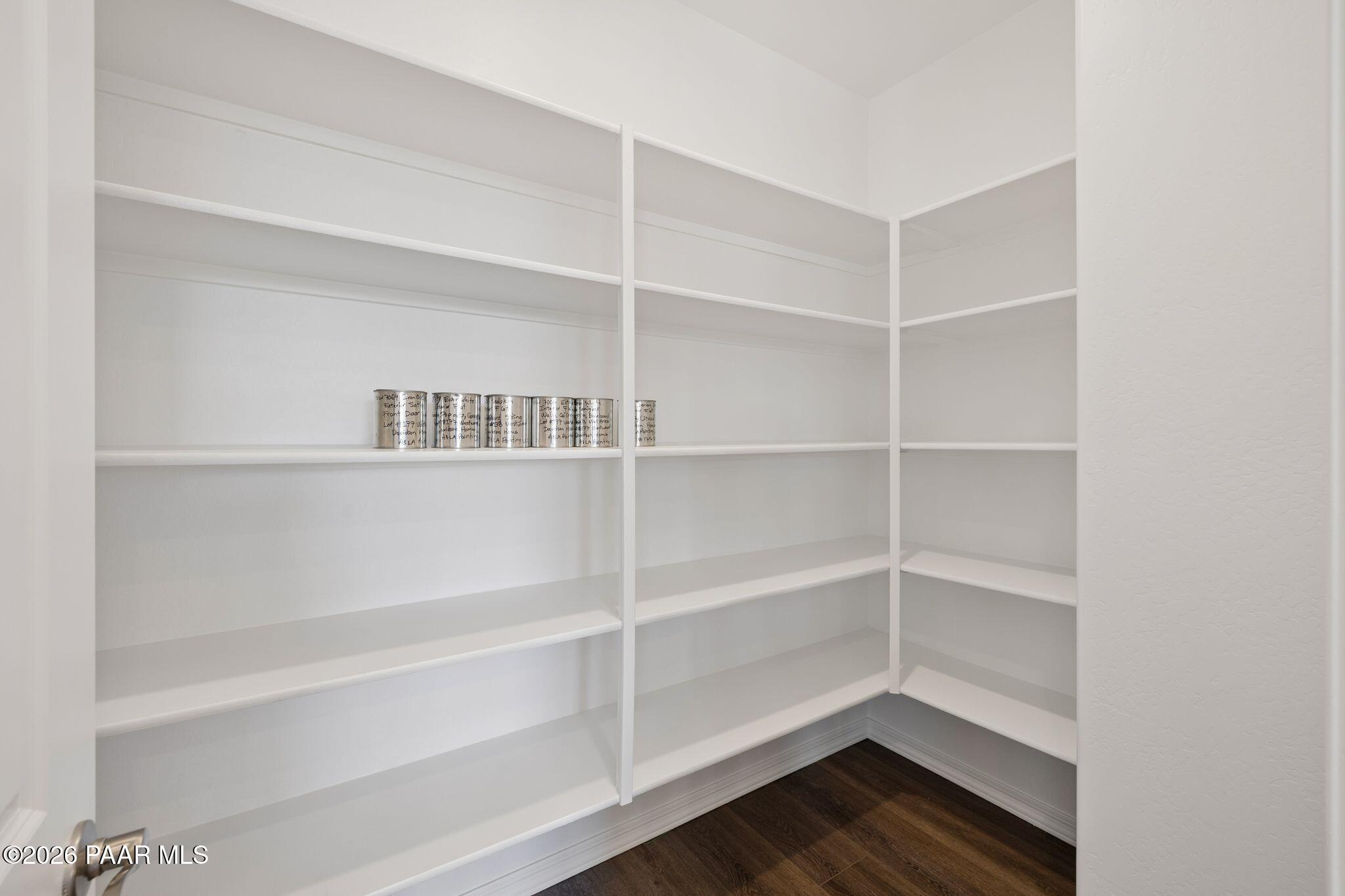 Spacious walk-in pantry with white shelves and canned goods in Davidson Homes The Monarch A, Prescott, Arizona