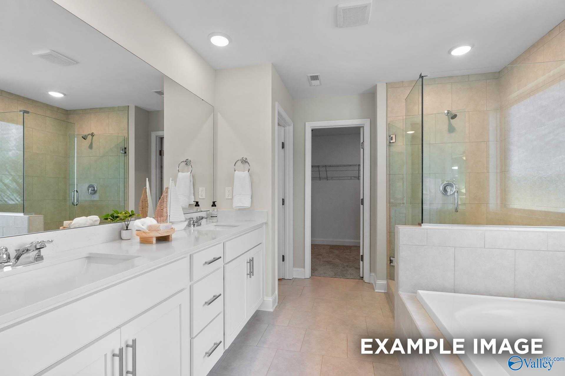 Luxurious master bathroom featuring double vanity, glass shower, freestanding tub in Davidson Homes Madison A, Harvest, AL