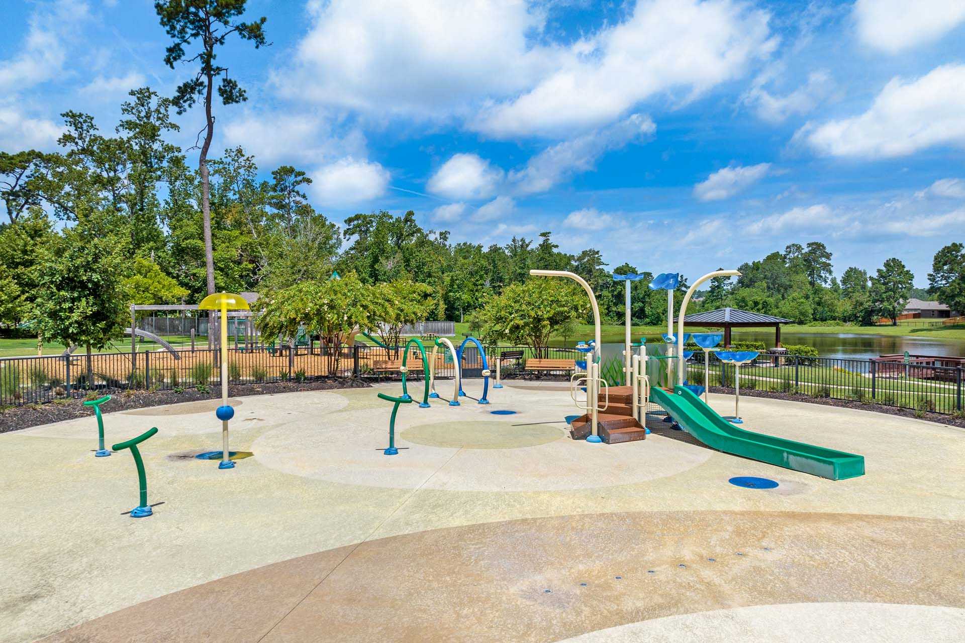 Children's splash pad at Lakes at Black Oak in Magnolia Texas with water sprays slides arches and playground features