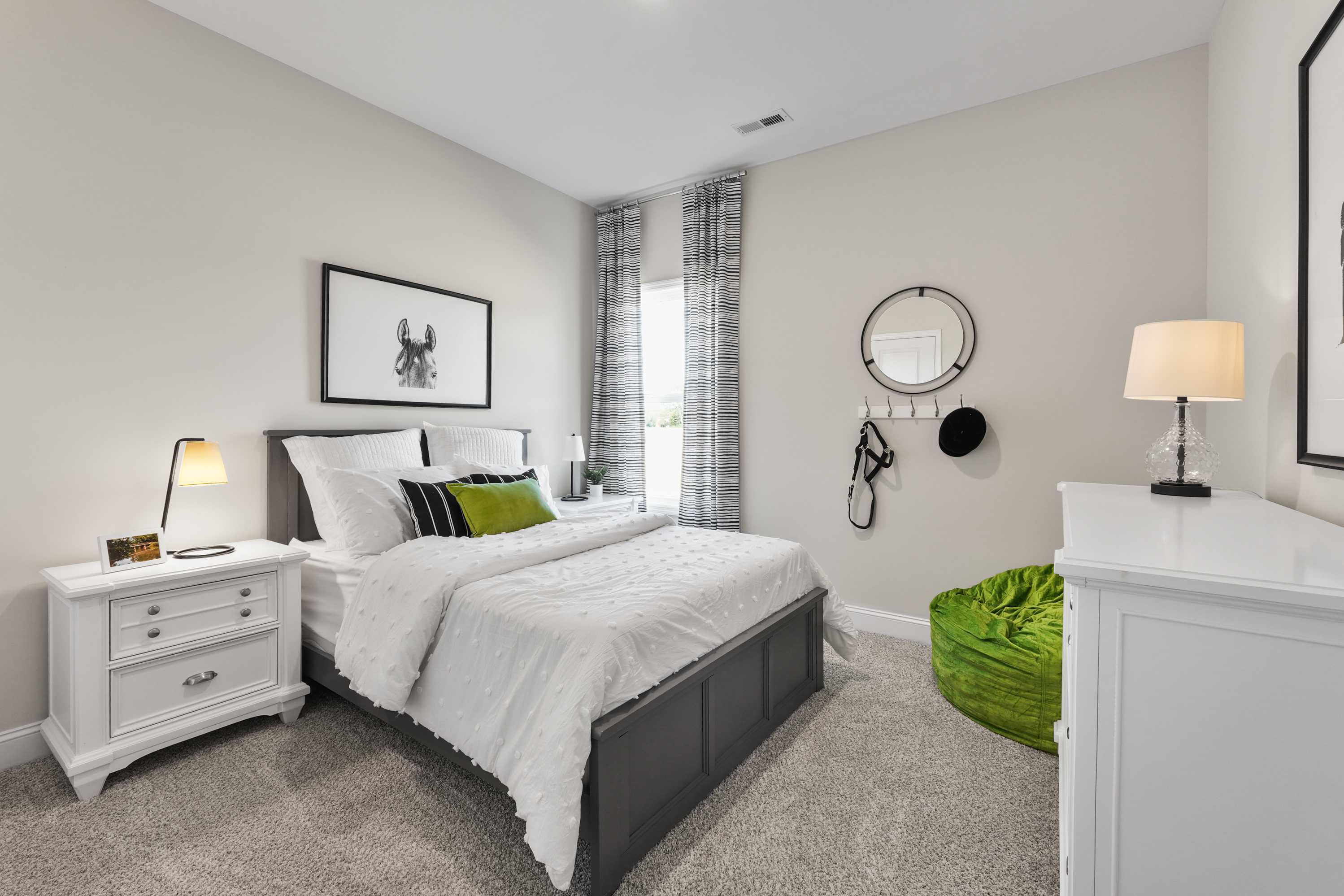 Cozy bedroom interior at Ramsay Cove in Owens Cross Roads AL with white platform bed, gray walls, green bean bag and modern lamps