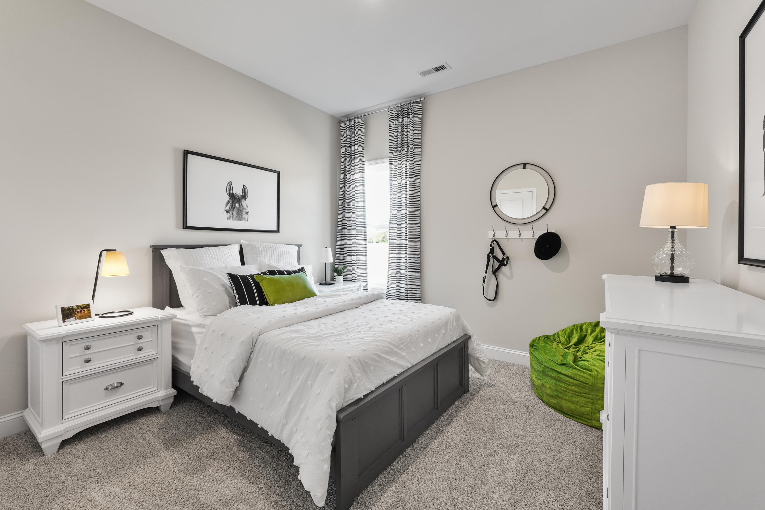 Cozy bedroom interior at Ramsay Cove in Owens Cross Roads AL with white platform bed, gray walls, green bean bag and modern lamps
