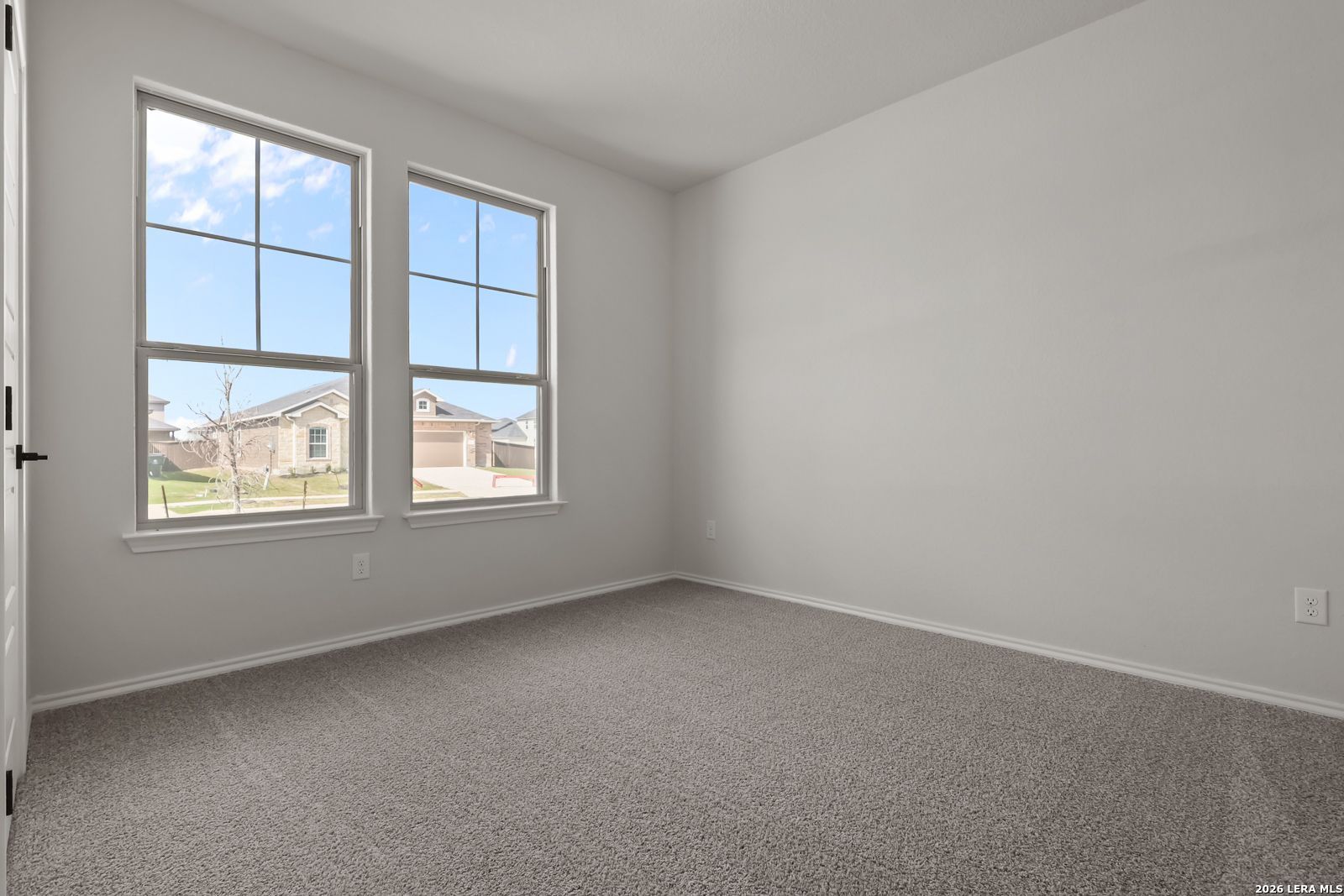 Bright secondary bedroom with large grid windows and green yard view in Davidson Homes The Daphne H, Seguin, Texas