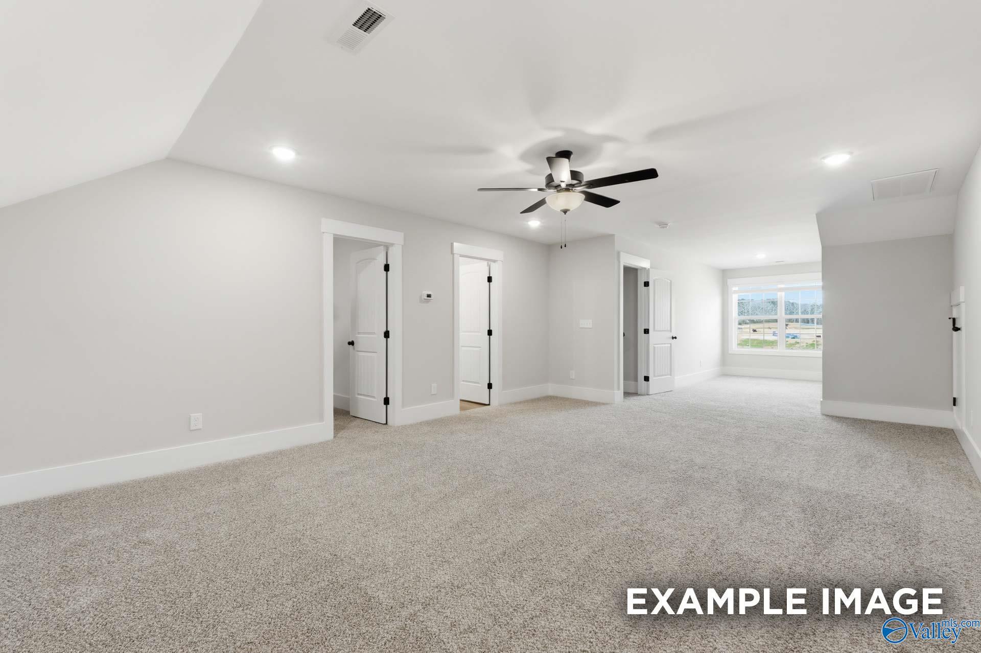 Spacious carpeted bonus room with ceiling fan in The Rockford floor plan by Davidson Homes in Briercreek, Meridianville.