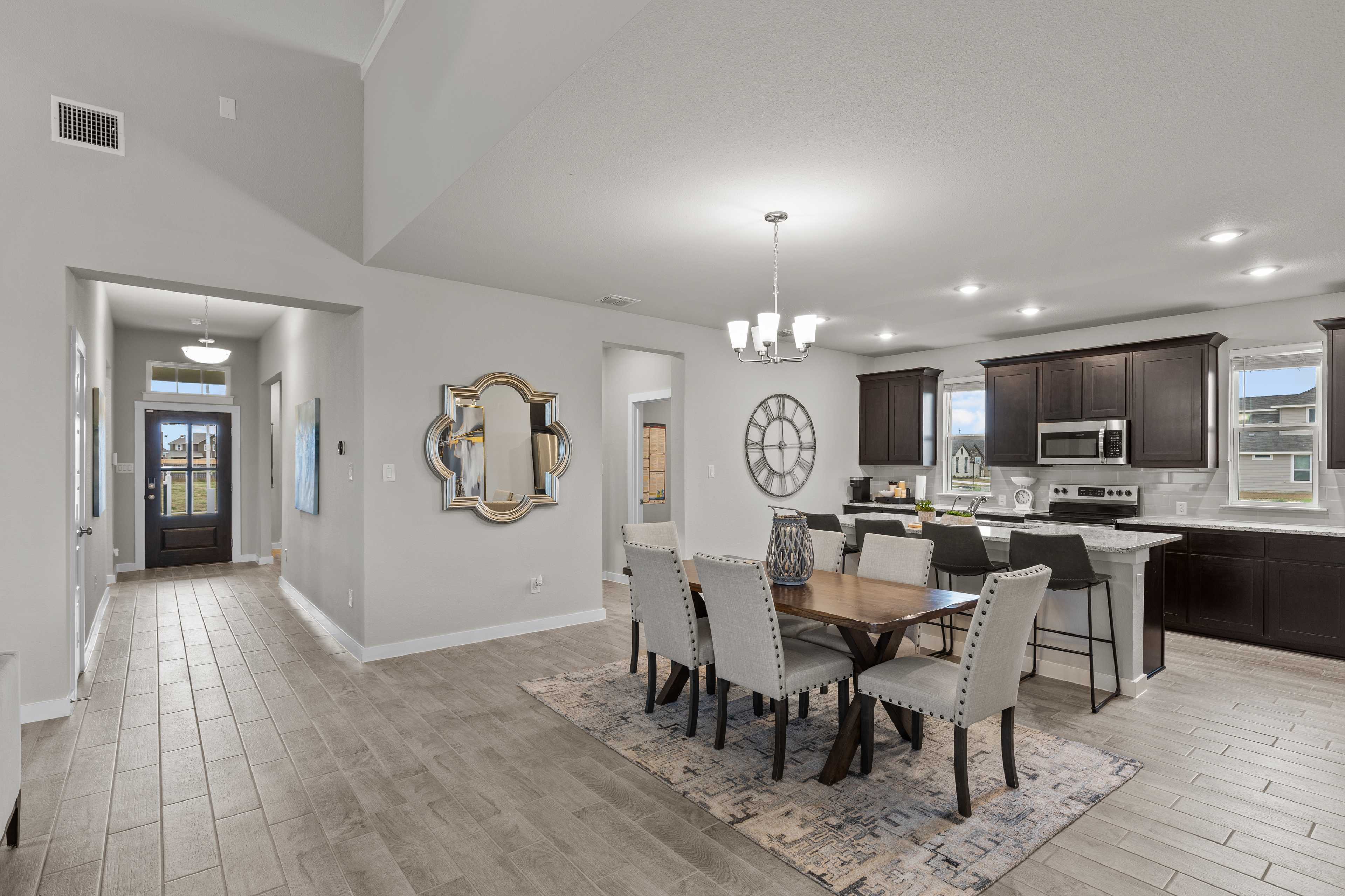 Open-concept kitchen and dining area in Hannah Heights Seguin Texas by Davidson Homes featuring modern island, dining table, and hallway view