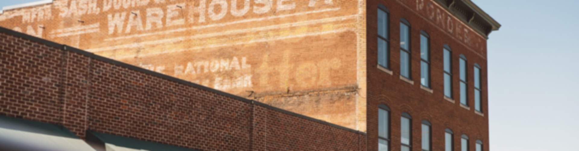 Historic red brick warehouse with faded C.W. Ponder Sash Doors & Building Materials sign in Cullman