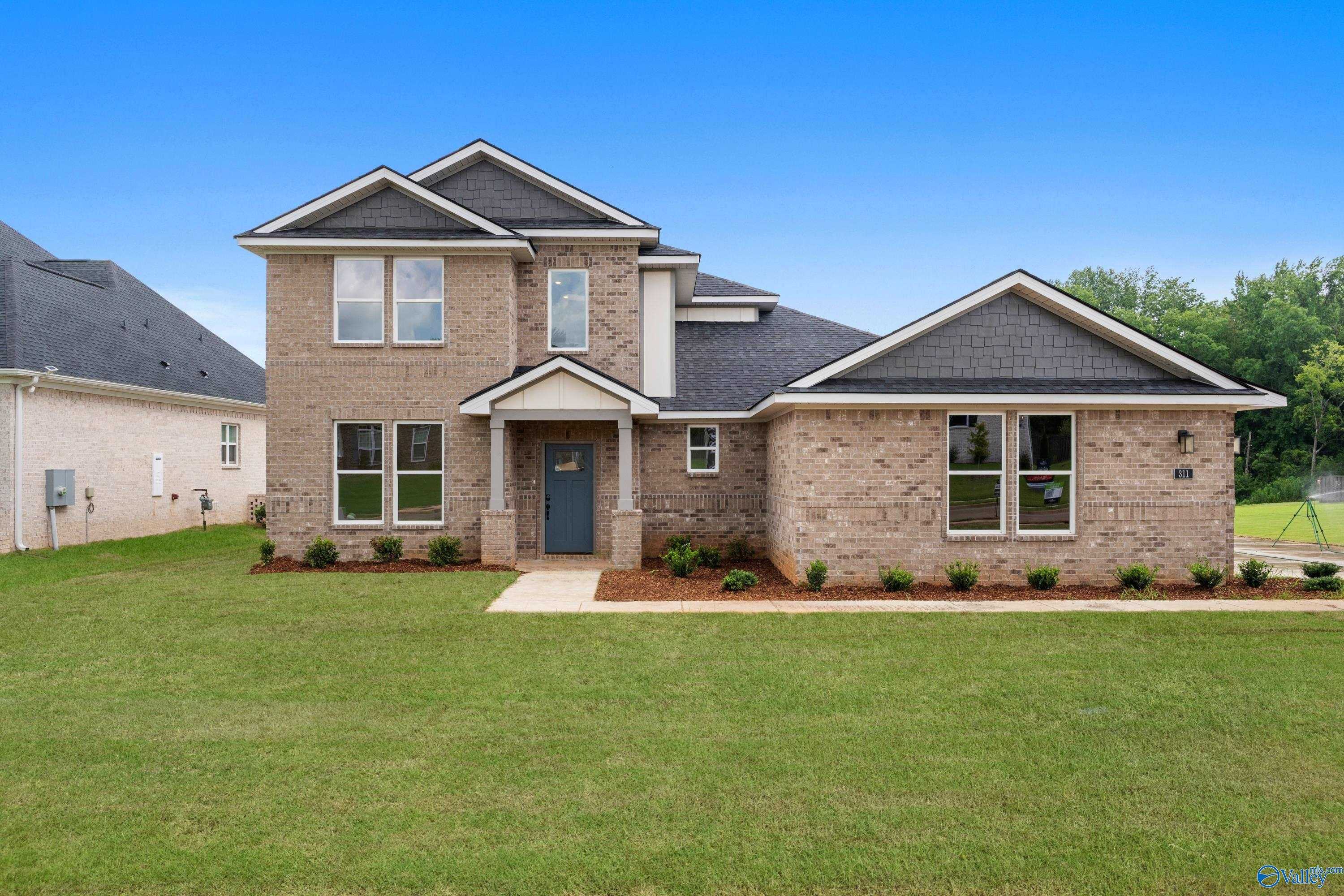 Two-story brick Dorado home with 3-car garage, covered entry, and manicured lawn in Riverton Preserve, Huntsville, Alabama