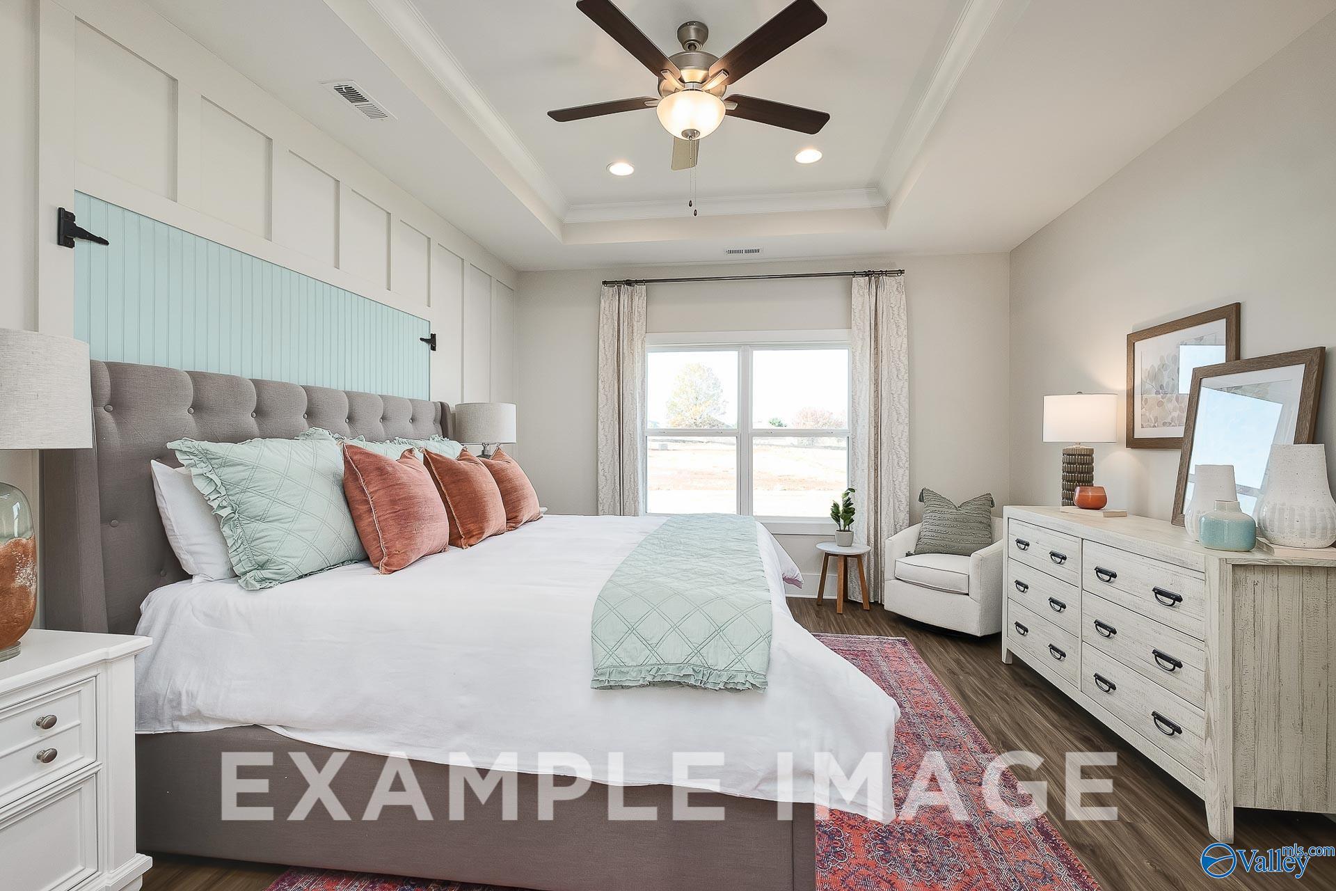 Master bedroom with tray ceiling and blue accent wall in The Everett B floor plan by Davidson Homes, Athens, Alabama.
