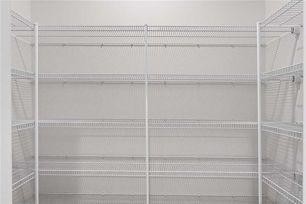 Spacious walk-in closet with white wire shelving in The Hickory B by Davidson Homes, Cedar Farms, Winder, Georgia