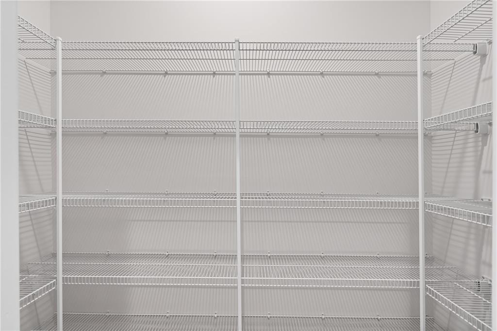 Spacious walk-in pantry with white wire shelving in 5-bedroom The Hickory A home by Davidson Homes, Winder, Georgia