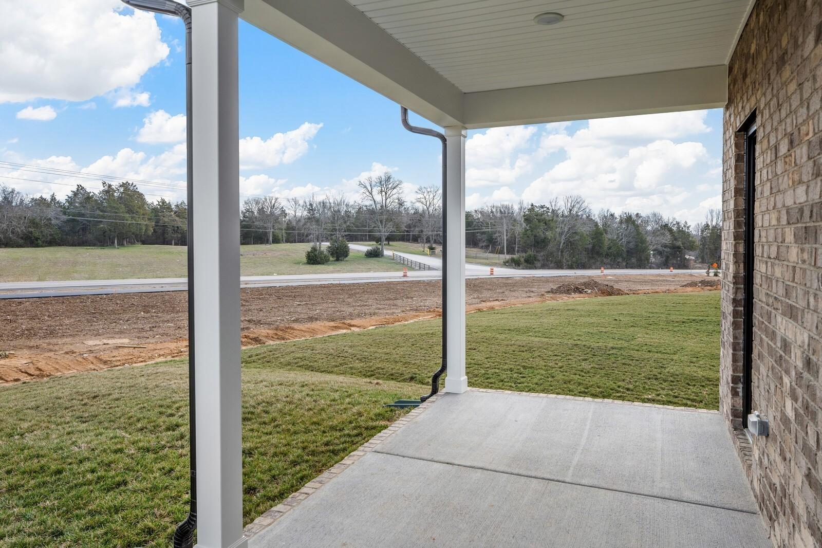 Covered concrete patio overlooking the scenic landscape of Benders Cove in Mt. Juliet, Tennessee by Davidson Homes.