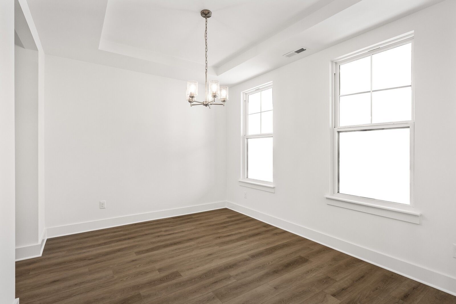 Elegant dining room with modern chandelier, large windows, and hardwood floors in Davidson Homes The Willow D, Mt. Juliet