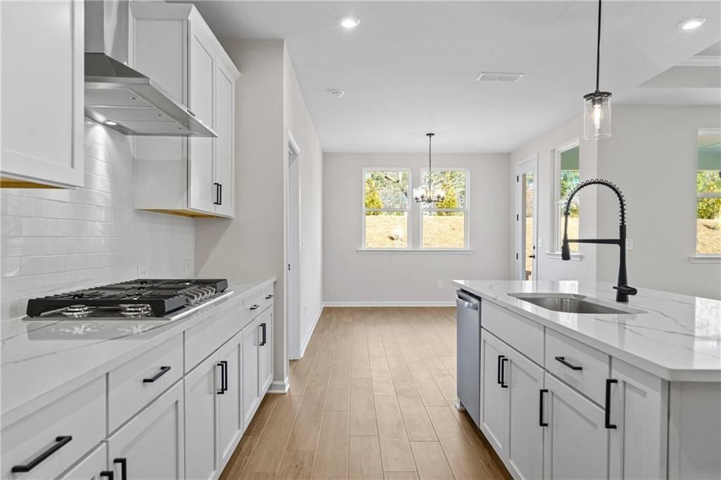 Modern white kitchen with quartz countertops, stainless appliances, subway tile backsplash in The Edison B, Kelly Preserve, Loganville GA