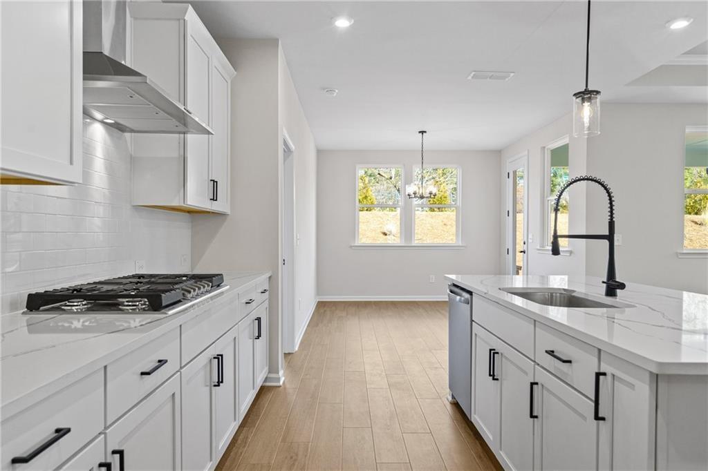 Modern white kitchen with quartz countertops, stainless appliances, subway tile backsplash in The Edison B, Kelly Preserve, Loganville GA