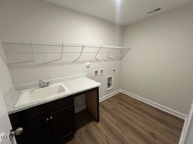 Laundry room with deep utility sink, dark cabinets, wire shelving, and wood-look flooring in Davidson Homes Willow D, Lillington NC